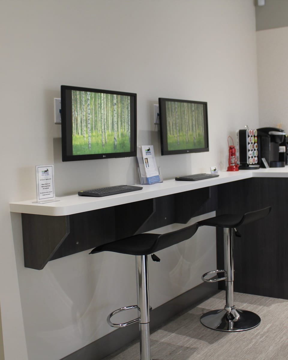 The courtesy internet bar at Moose Lake Dental, with two screens and two stools