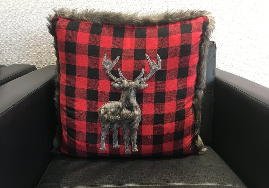 A red plaid cushion with a pewter moose on a lounge chair at Moose Lake Dental